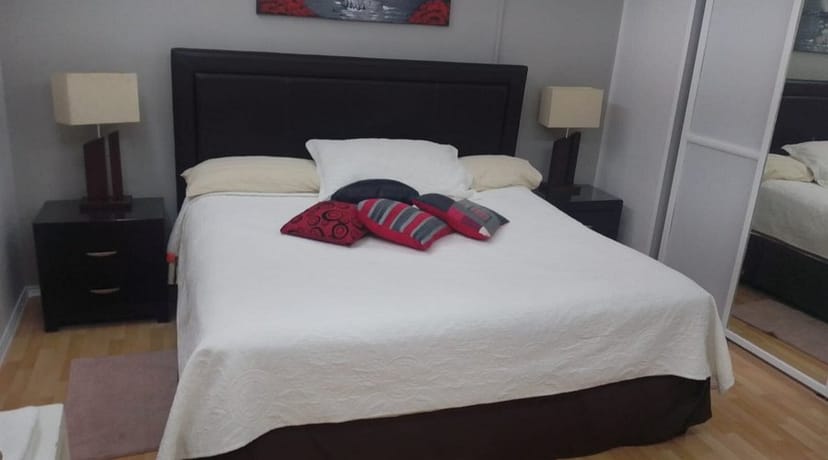 Standard hotel room at Suites del Valle featuring dated décor for travel and vacation booking.
