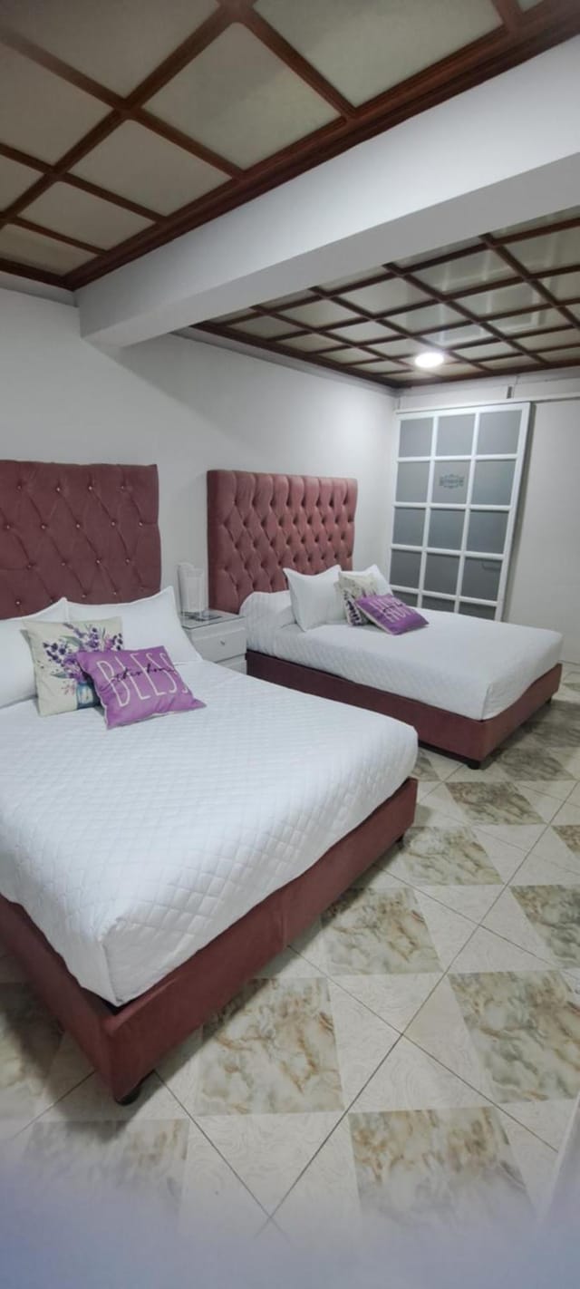 Double-occupancy hotel room at Suites del Valle for conference accommodation.