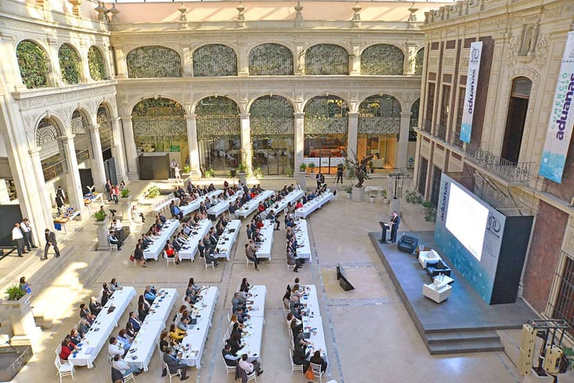Salón Banderas event space with banquet seating for corporate conferences and formal presentations.