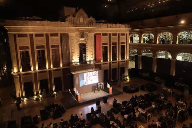 Salón Banderas venue with dramatic uplighting for corporate presentations and evening events.