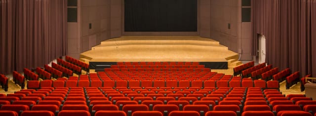 Salle Paderewski auditorium with red seating for keynote presentations and panel discussions.