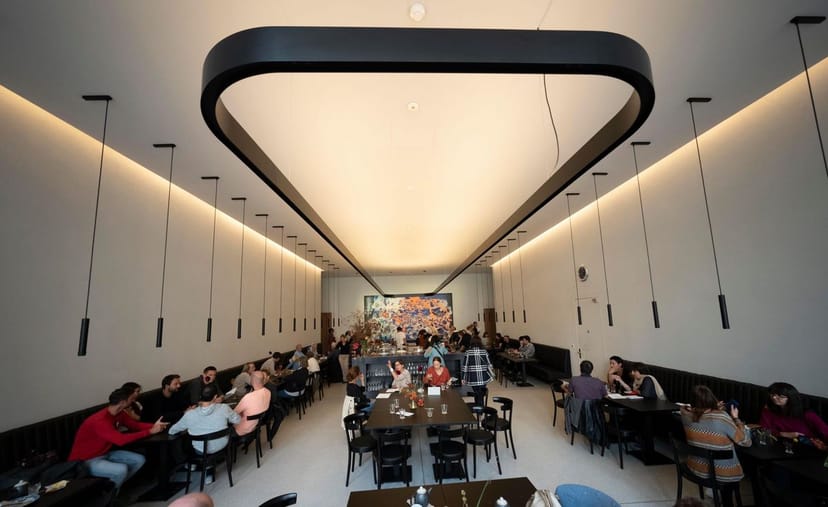 Modern restaurant event space with architectural lighting for corporate luncheons and networking.