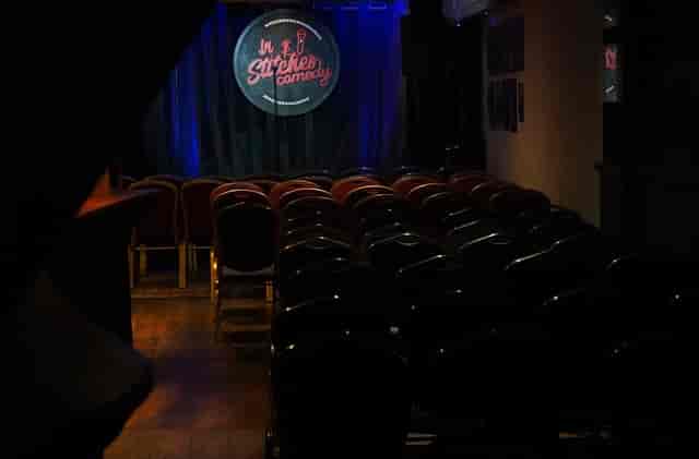 In Stitches Comedy club theater stage with focused lighting for intimate stand-up comedy shows.