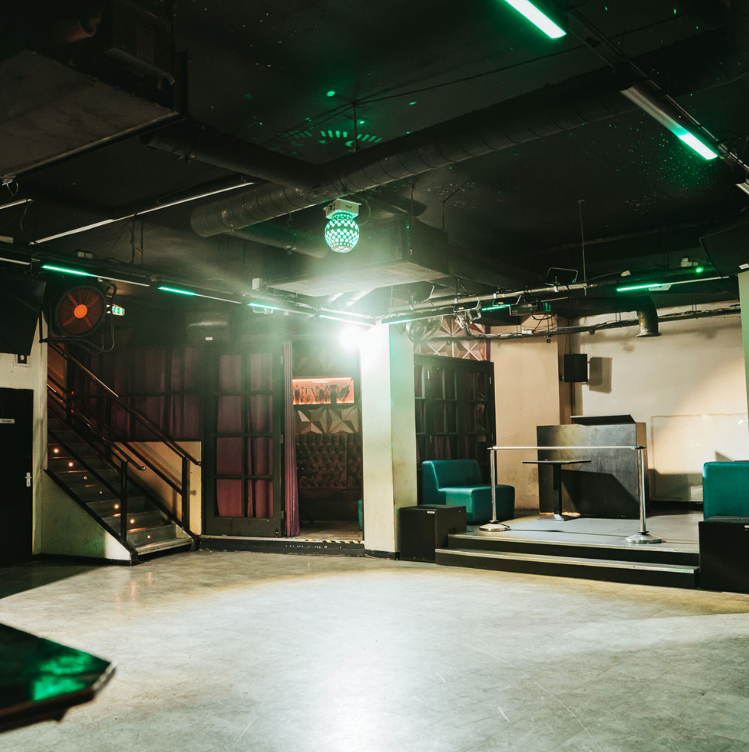 Industrial venue with stage and lounge seating for evening receptions and product launches.