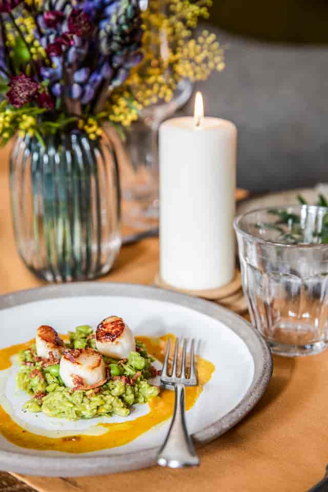 Elegant seared scallops dish in sophisticated lounge setting for upscale events.