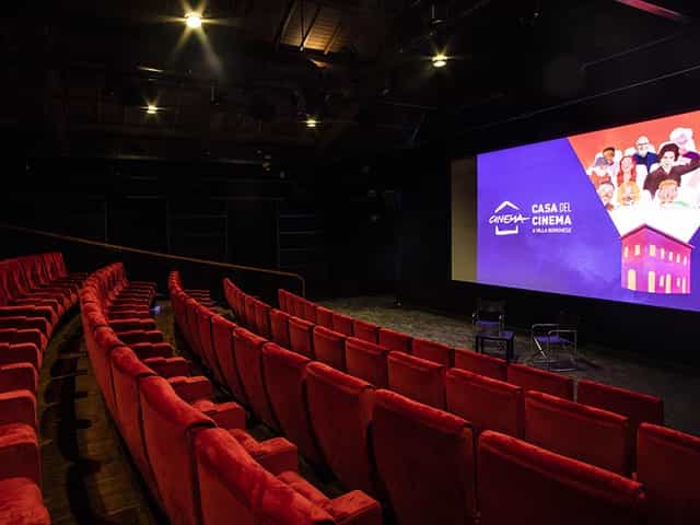 Sala Cinecittà: plush red seating and large screen for film screenings and events.