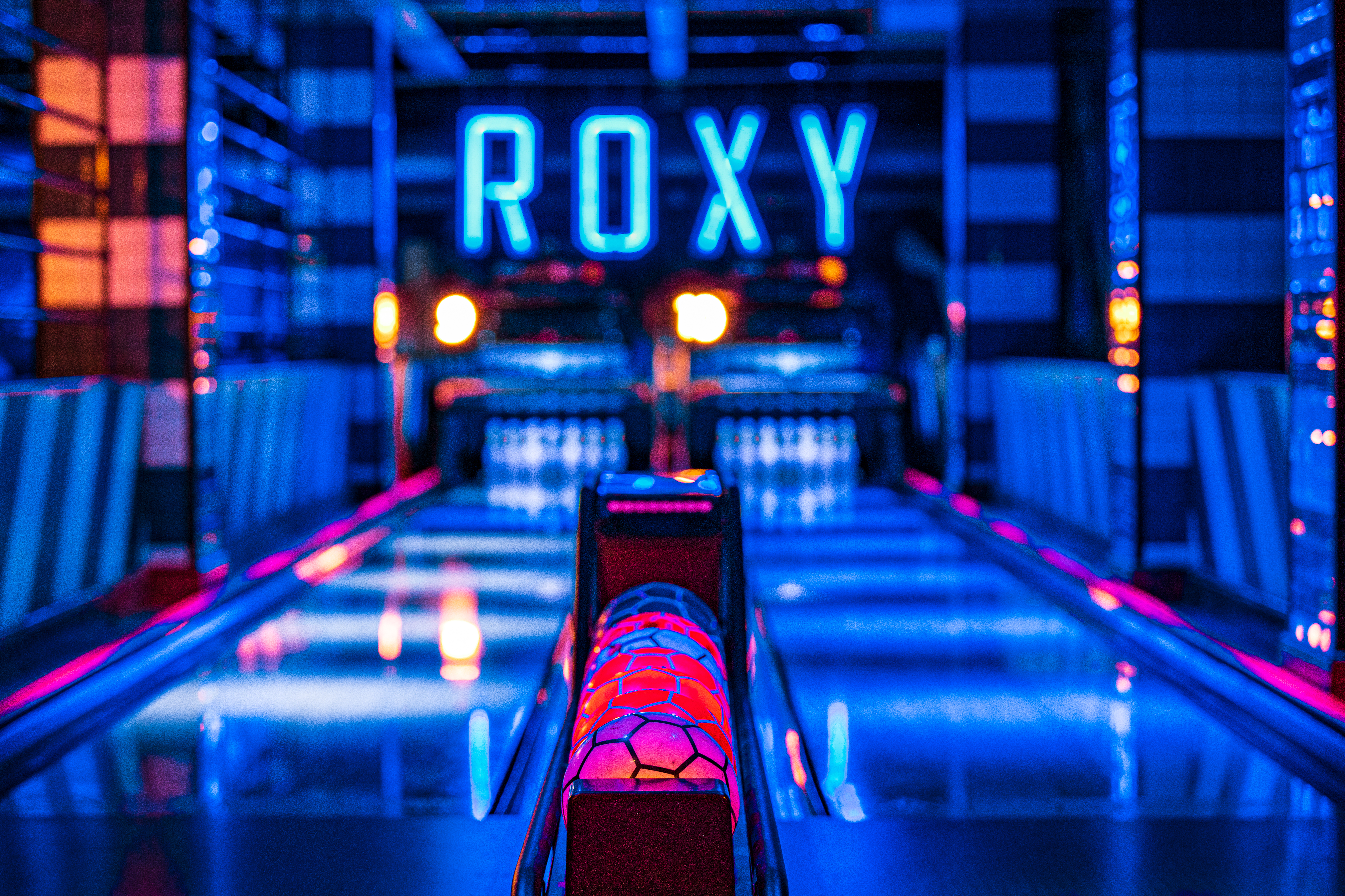 Vibrant neon-lit bowling alley at Roxy Lanes, perfect for corporate events and gatherings.