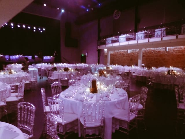 Black Hall event space featuring purple uplighting for formal banquet and corporate gala.