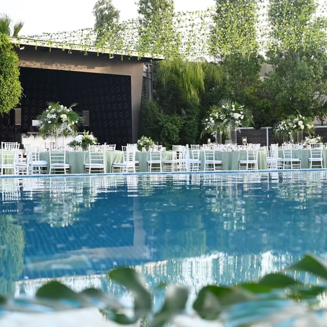 Garden ceremony area with white Chiavari chairs for luxury weddings and corporate gala events.