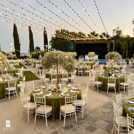 Outdoor evening wedding reception at BASE Events with baby's breath centerpieces and string lighting.