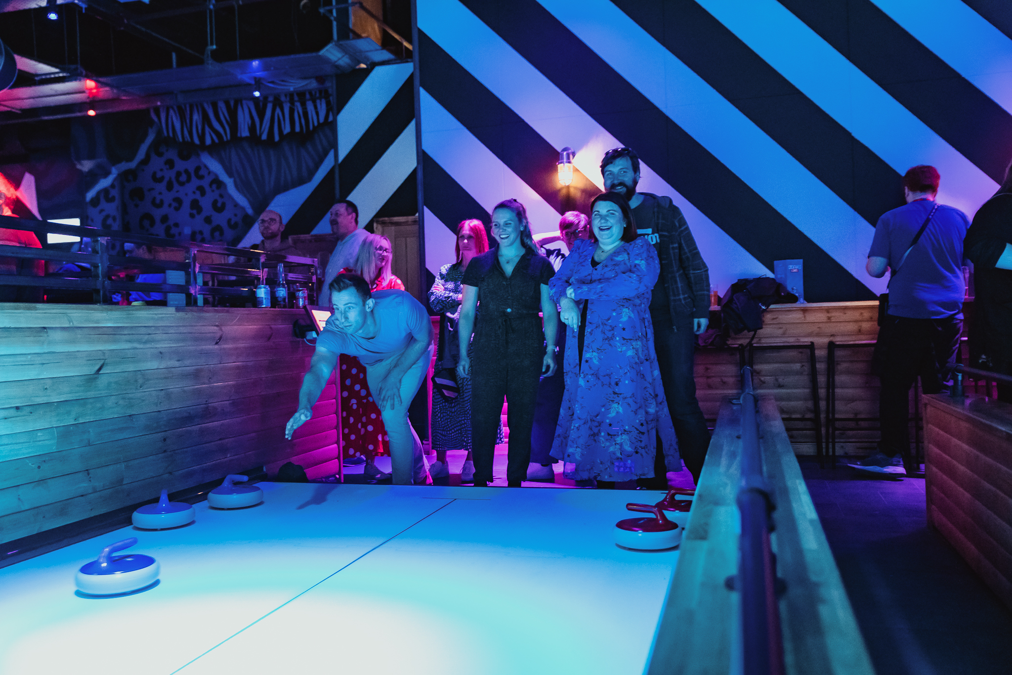 Lively curling event at The Lodge, Roxy Lanes Cardiff with vibrant decor and networking fun.