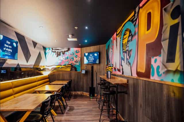 Vibrant karaoke room with graffiti art for creative meetings and events in Manchester.