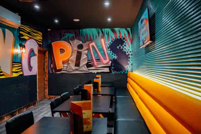 Vibrant karaoke room with graffiti art and orange seating for events in Manchester.
