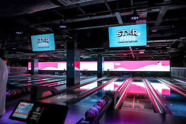 Strike and Slide venue with neon lighting for corporate team building and social mixer events.