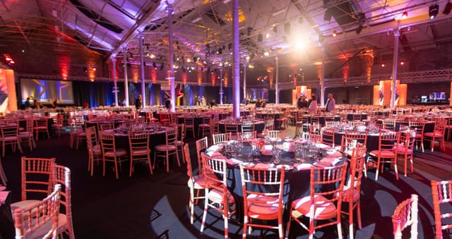 Elegant Main Hall setup for corporate events with vibrant lighting and round tables.