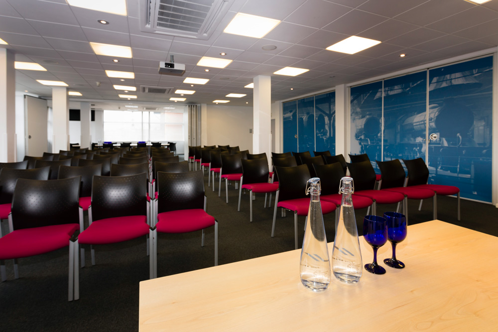 Mallard Suite in National Railway Museum, a bright meeting space with black chairs and pink accents.