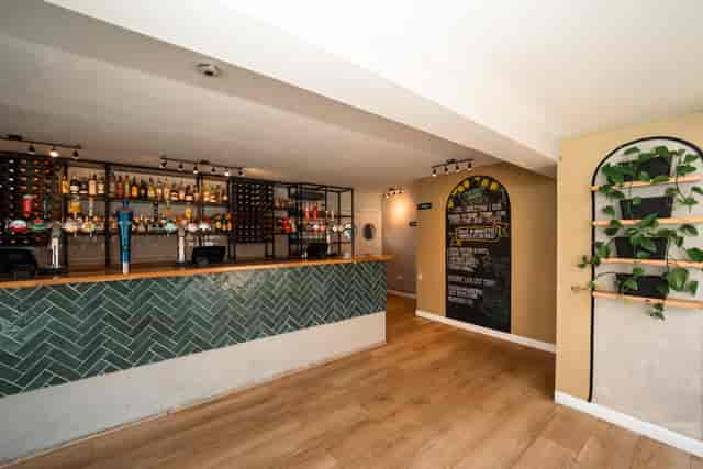 Modern bar area with herringbone design, perfect for networking events and meetings.