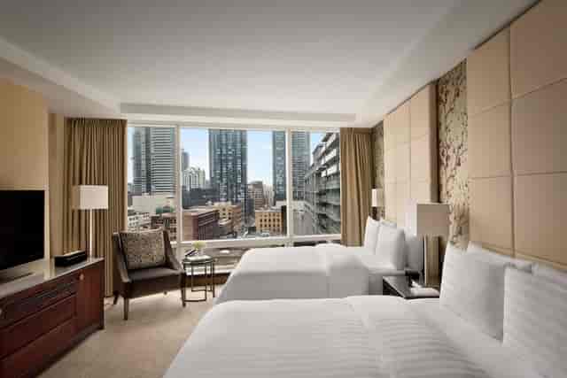 Premier one-bedroom hotel suite with floor-to-ceiling windows for conference accommodation.