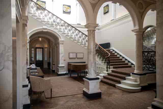 Elegant Beaverbrook venue entryway with sweeping staircase for networking events.