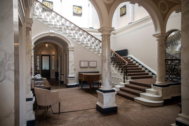 Elegant Beaverbrook venue entryway with sweeping staircase for networking events.
