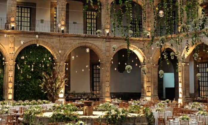Luxury gala venue at Ex Convento San Hipolito featuring dramatic stone arches and greenery.
