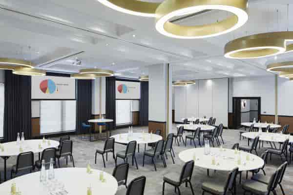 Modern ballroom at London Marriott Maida Vale with banquet tables for corporate conferences.