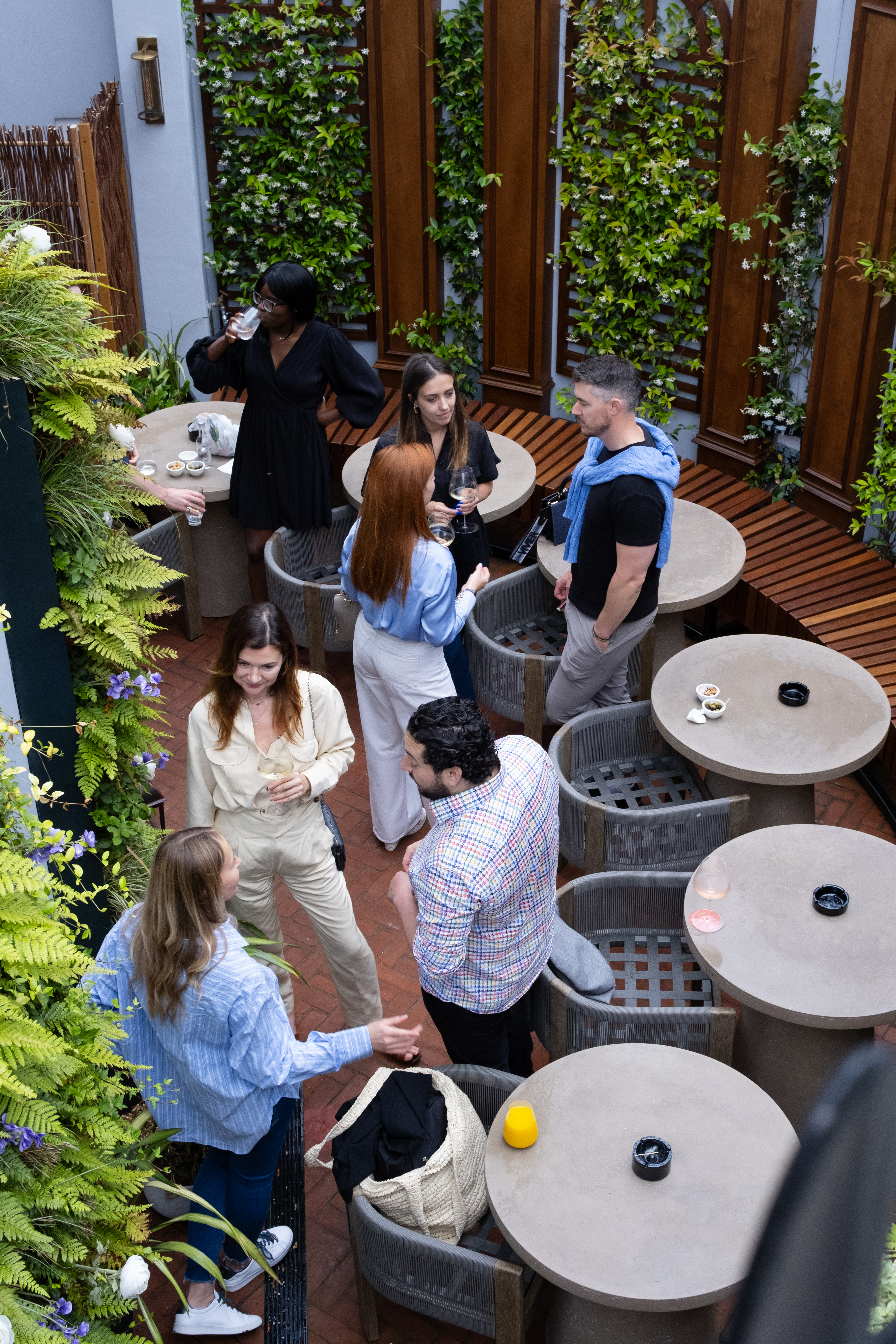 Intimate networking event at 2 Chesham Hotel's lush outdoor terrace, promoting connections.