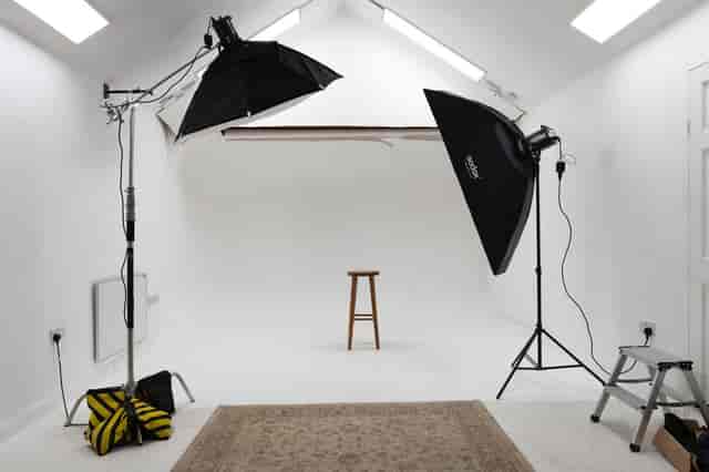 All-white photography studio with adjustable lighting for workshops and webinars.