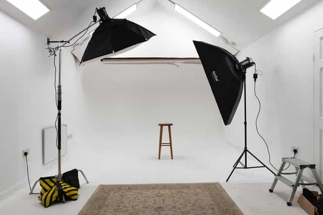 All-white photography studio with adjustable lighting for workshops and webinars.