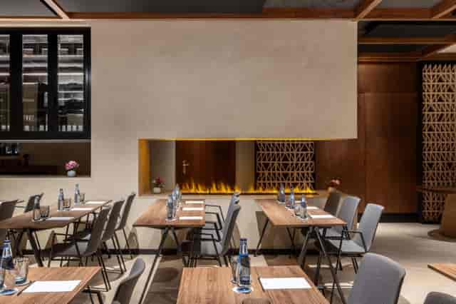 "Elegant meeting space in Radisson Sevilla with stylish fire feature, ideal for events."