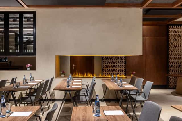 "Elegant meeting space in Radisson Sevilla with stylish fire feature, ideal for events."