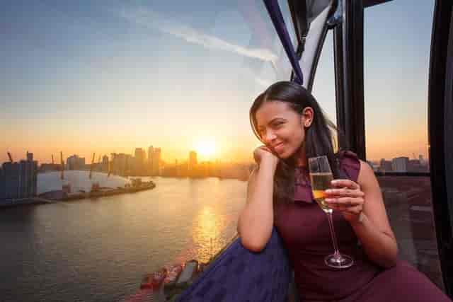 Elegant woman in London Cable Car Cabin at sunset, ideal for networking events and celebrations.