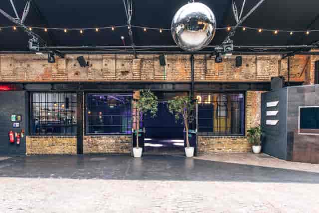 Versatile industrial event space with disco ball for corporate and social gatherings.