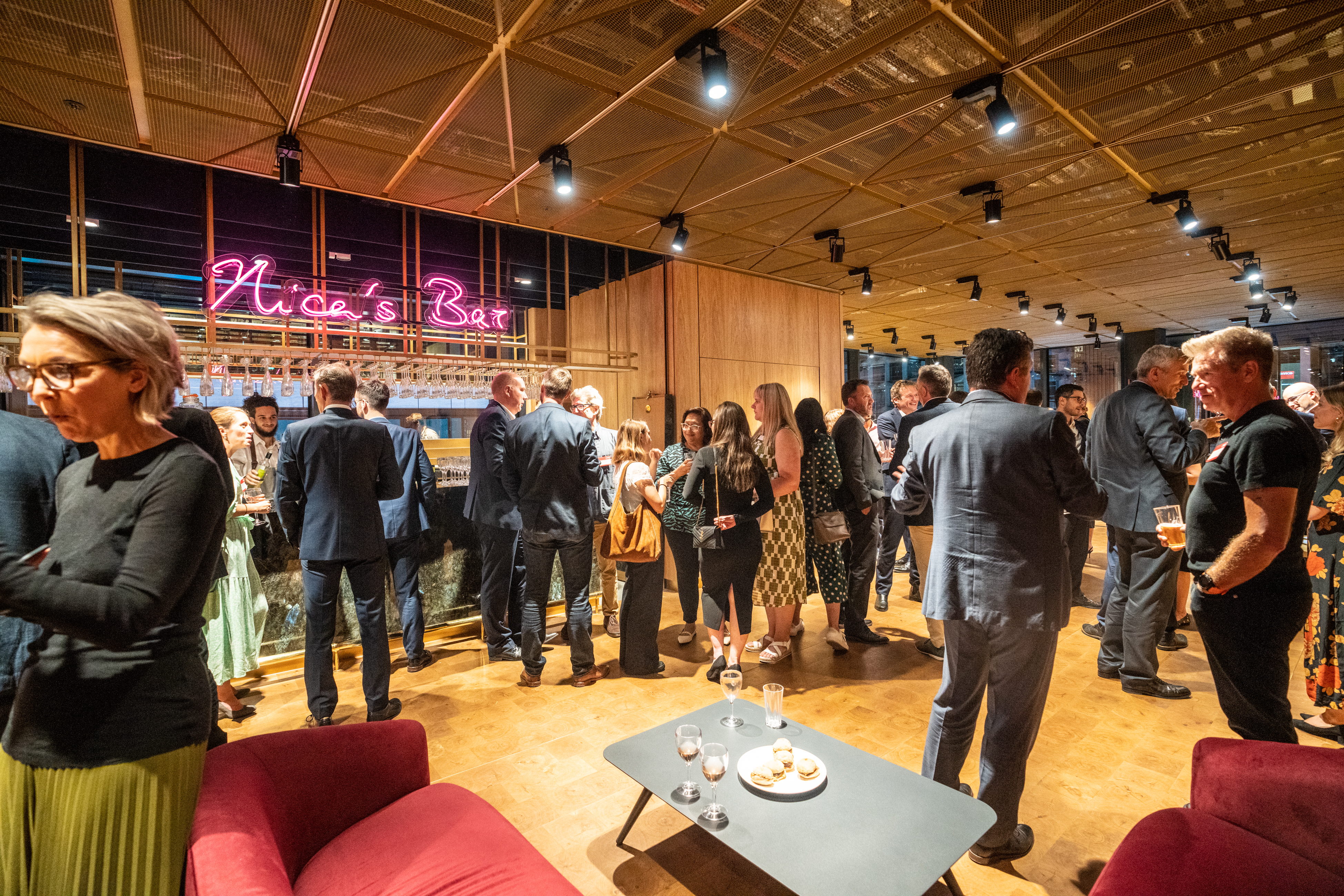 Networking event at Nica's Bar, modern decor and neon signage in London's West End.