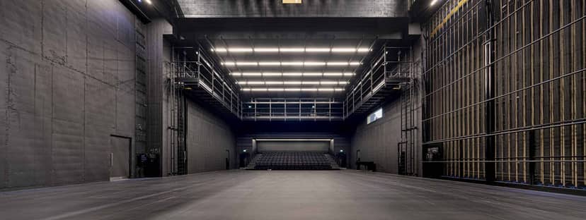 Industrial black-box venue with overhead rigging for event production and stage design.