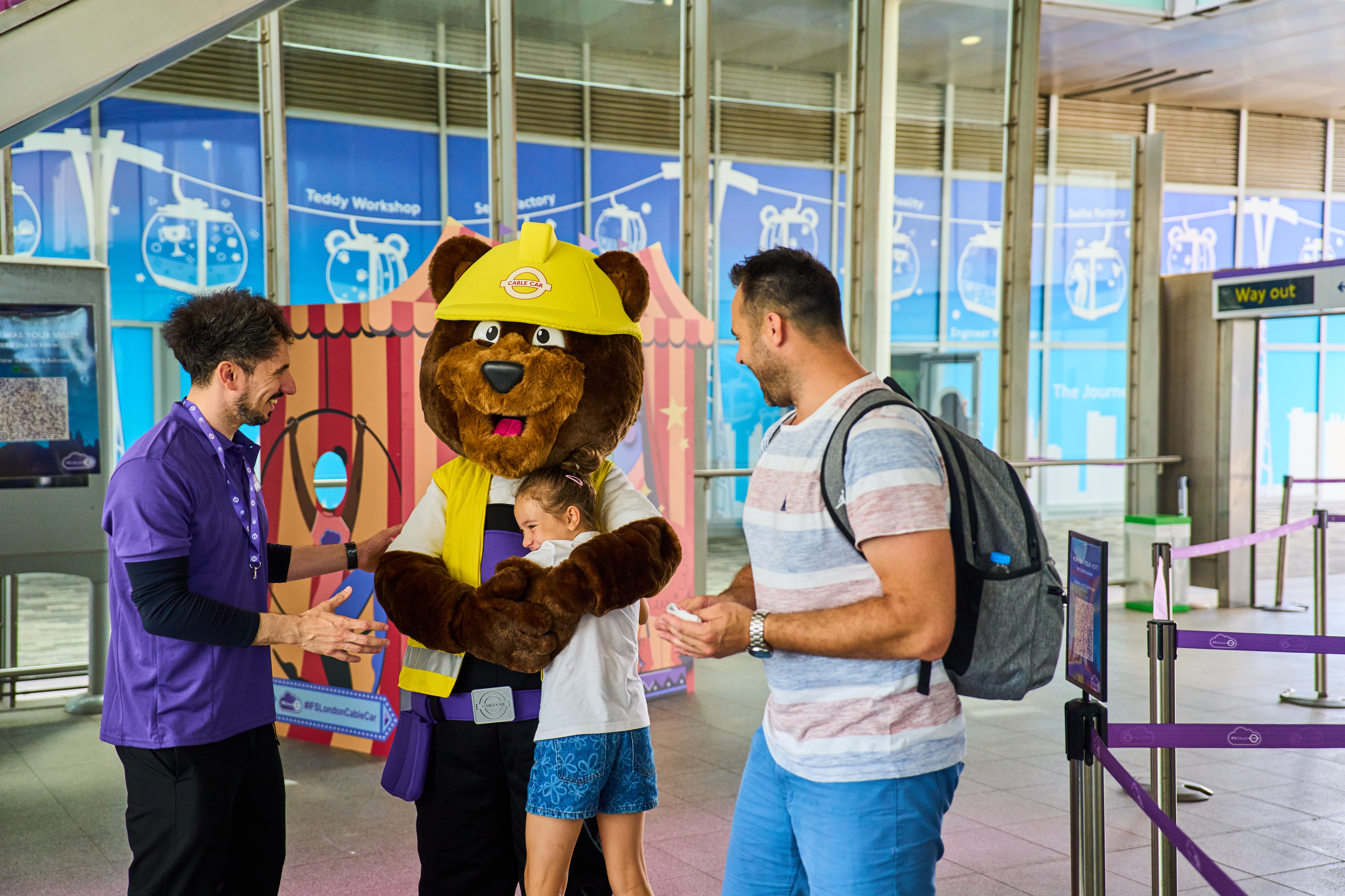 Cheerful mascot engaging families at London Cable Car event, focusing on audience interaction.