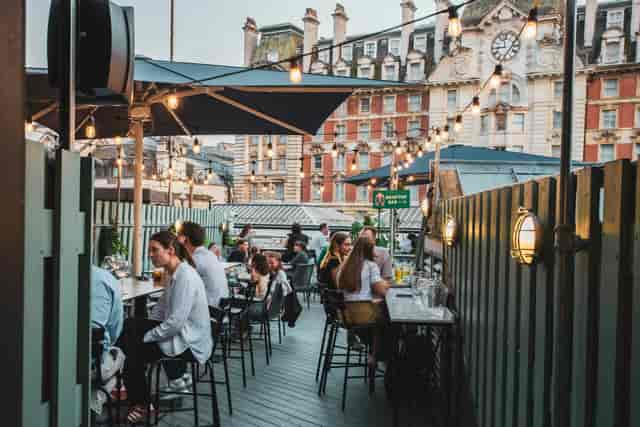 Rooftop restaurant with string lighting for corporate mixers and social receptions.