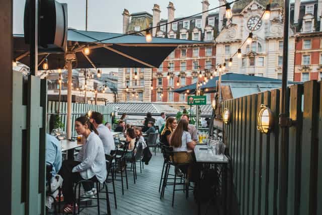 Rooftop restaurant with string lighting for corporate mixers and social receptions.
