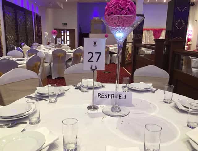 Elegant corporate event setup with floral centerpieces at The Grand Astoria venue.