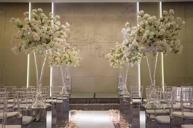 Luxury wedding ceremony with tiered floral pedestals and ghost chairs at Four Seasons Toronto.
