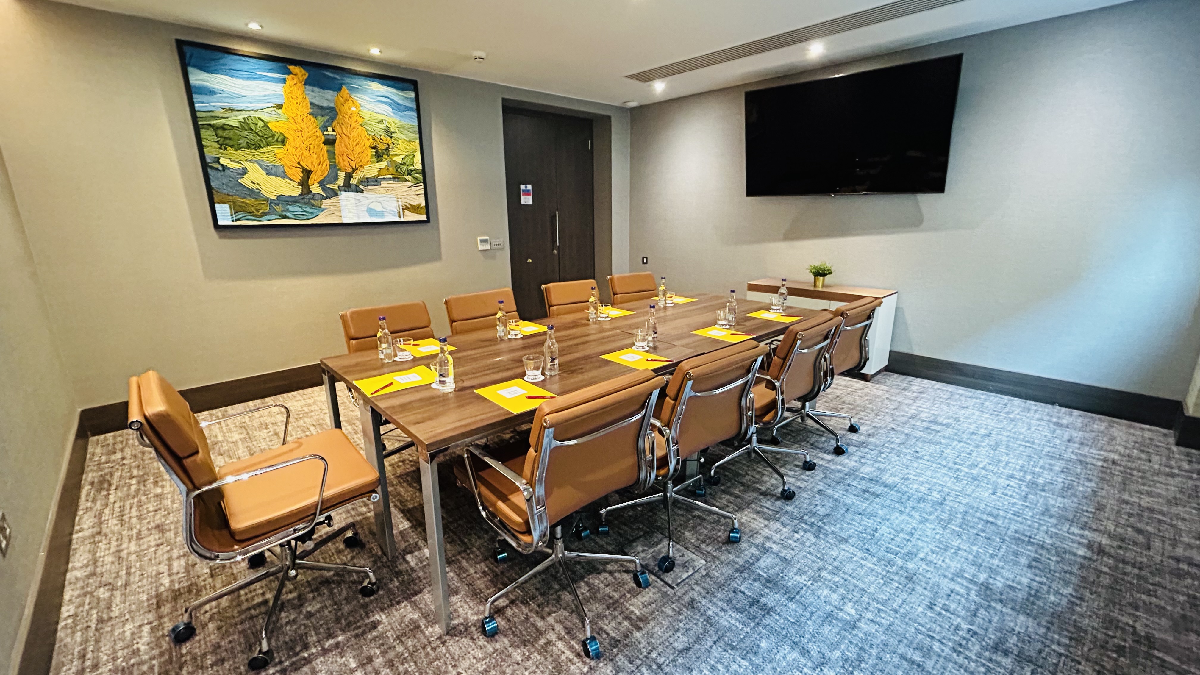 Wimbledon Suite at Crowne Plaza: elegant meeting room with wooden table, ideal for corporate events.