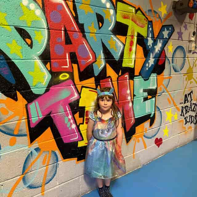 Juniors and Mini class at Sxefit Studios posing against a vibrant graffiti selfie station backdrop.