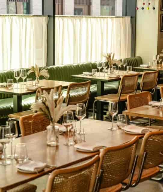 Daffodil Mulligan dining layout with green banquettes for breakfast and networking events.