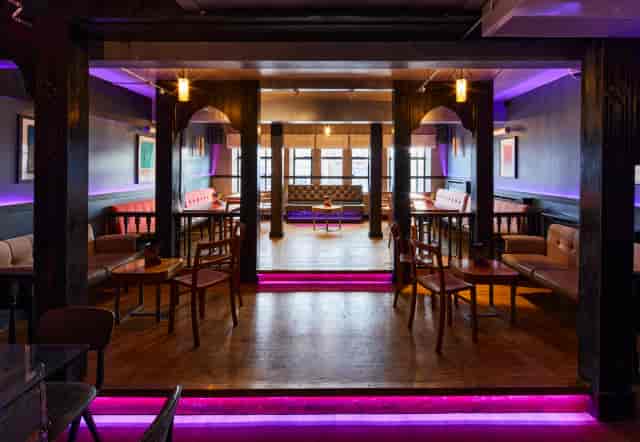 Lounge cocktail bar with purple ambient lighting for networking events and upscale receptions.