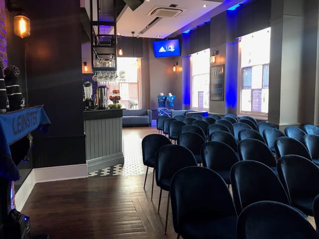 Modern event space with plush chairs, ideal for meetings and presentations at The Thirsty Scholar.