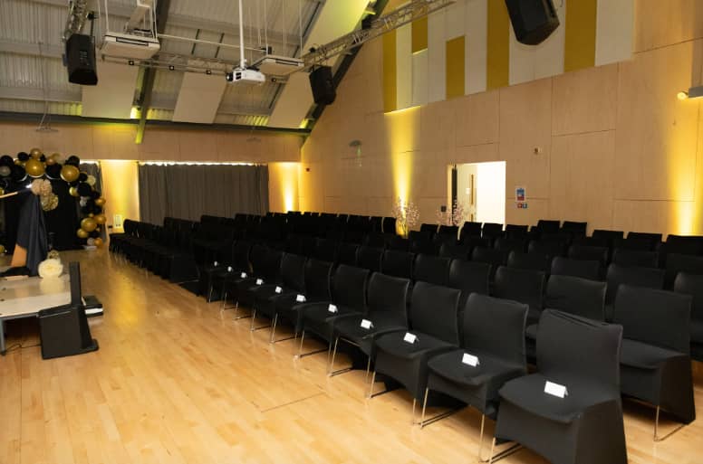 Theatre-style setup in Adrian Cadbury Hall with stage and AV for professional presentations.