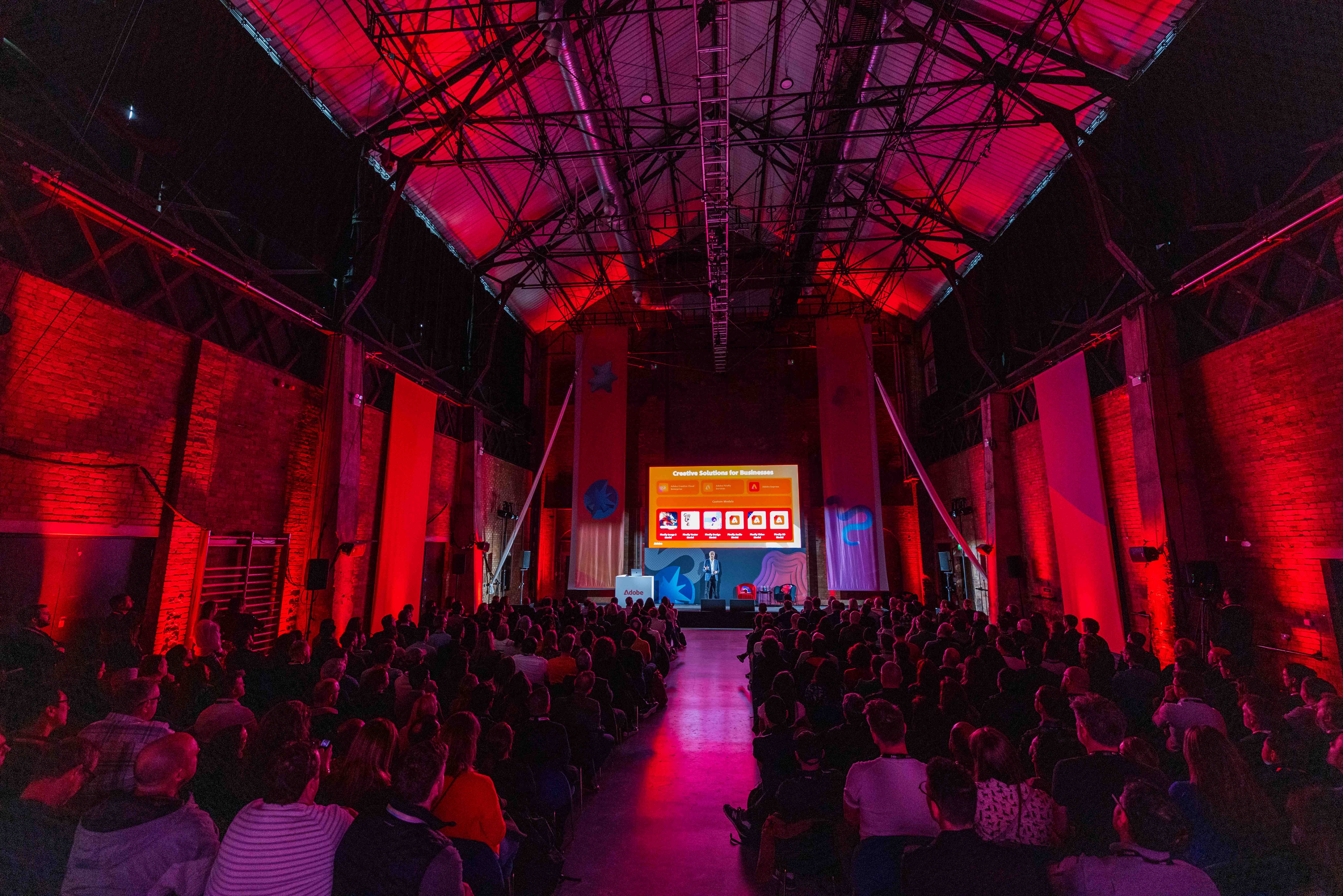 Vibrant Shoreditch event space with red lighting, ideal for presentations and networking.