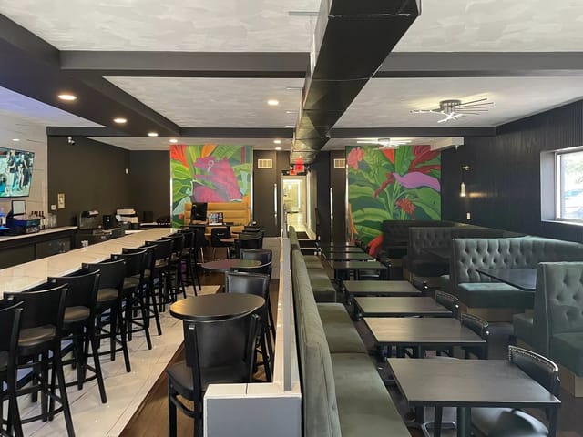 Modern event space in The Rock Steakhouse with vibrant murals and bar.