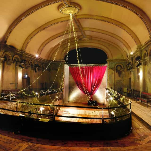 Ballroom + Chapel venue with red draping and fairy lights for boutique weddings and private events.