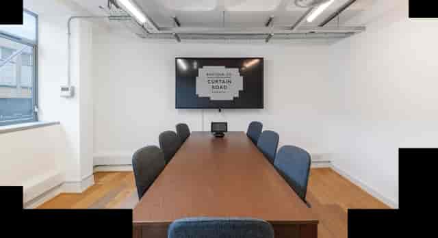 Modern meeting room with wooden table, blue chairs for corporate events and presentations.